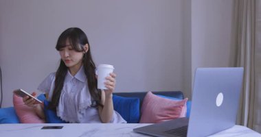 Japon bir kadın oturma odasında akıllı telefondan alışveriş yapıyor. Yüksek kalite 4K görüntü. Tokyo Japonya 06.12.2025