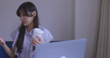 Japon bir kadın oturma odasında akıllı telefondan alışveriş yapıyor. Yüksek kalite 4K görüntü. Tokyo Japonya 06.12.2025