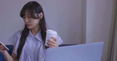 Japon bir kadın oturma odasında akıllı telefondan alışveriş yapıyor. Yüksek kalite 4K görüntü. Tokyo Japonya 06.12.2025