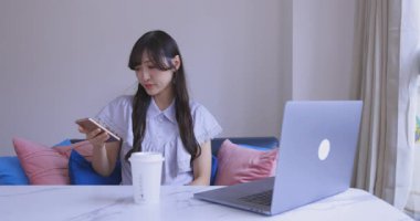 Japon bir kadın oturma odasında akıllı telefondan alışveriş yapıyor. Yüksek kalite 4K görüntü. Tokyo Japonya 06.12.2025