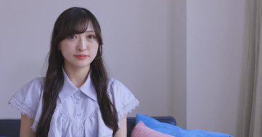 Japon bir kadın oturma odasında akıllı telefondan alışveriş yapıyor. Yüksek kalite 4K görüntü. Tokyo Japonya 06.12.2025