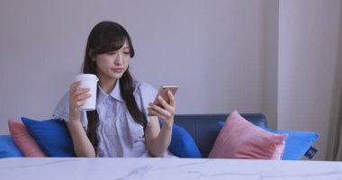 Japon bir kadın oturma odasında akıllı telefondan alışveriş yapıyor. Yüksek kalite 4K görüntü. Tokyo Japonya 06.12.2025