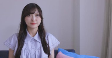 Japon bir kadın oturma odasında akıllı telefondan alışveriş yapıyor. Yüksek kalite 4K görüntü. Tokyo Japonya 06.12.2025