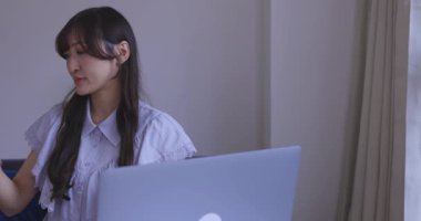 Japon bir kadın oturma odasında akıllı telefondan alışveriş yapıyor. Yüksek kalite 4K görüntü. Tokyo Japonya 06.12.2025