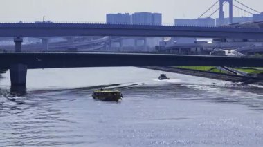 Tokyo 'da nehirde yüzen bir geminin zaman çizelgesi. Yüksek kalite 4K görüntü. Koto bölgesi Ariake Tokyo 08.21.2025
