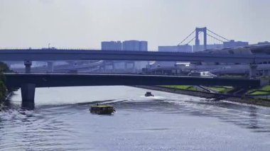 Tokyo 'da nehirde yüzen bir geminin zaman çizelgesi. Yüksek kalite 4K görüntü. Koto bölgesi Ariake Tokyo 08.21.2025