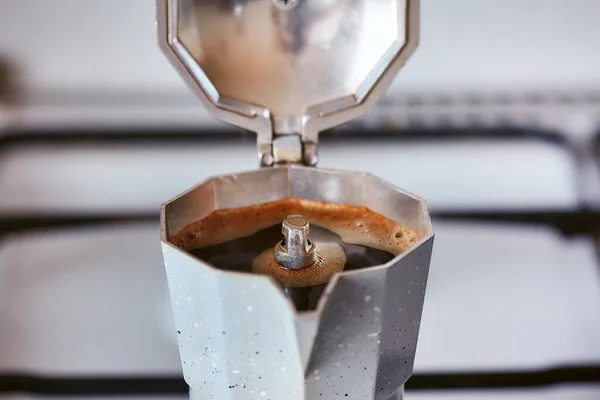 Gaz ocağındaki bir gayzer kahve makinesi bir porsiyon kahve üretir.