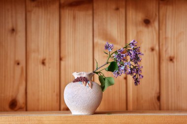 Ahşap arka planda çiçekli bir vazo.