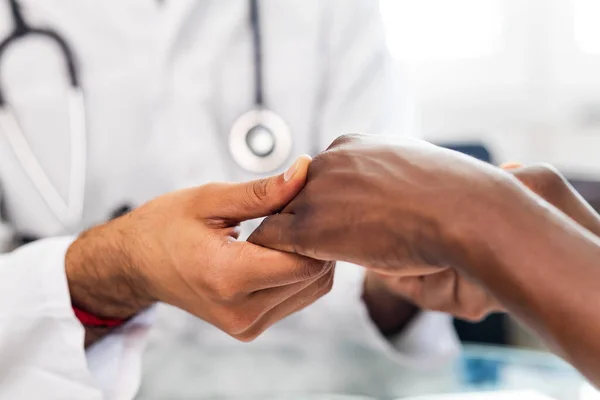Friendly doctor hands holding patient hand support and hope concept.