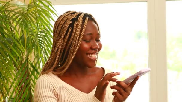 Tevreden Afro Amerikaanse Vrouw Typt Sms Bericht Mobiele Telefoon Thuis — Stockvideo
