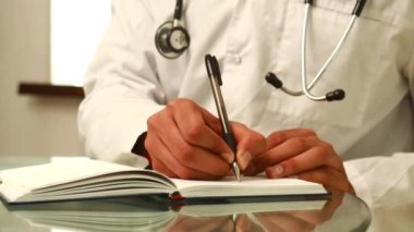 Hintli doktor üniforma giyiyor. Tıbbi belgelere not alıyor..