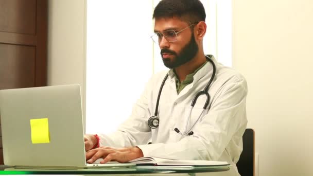 Médico Indio Vistiendo Uniforme Tomando Notas Documentos Médicos Portátiles — Vídeos de Stock
