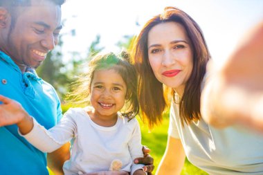 Mutlu aile günbatımı yaz parkında birlikte vakit geçiriyor..