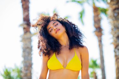 Uzun kıvırcık saçlı çok kültürlü bir kadın kendini güçlü ve korkusuz hissediyor..