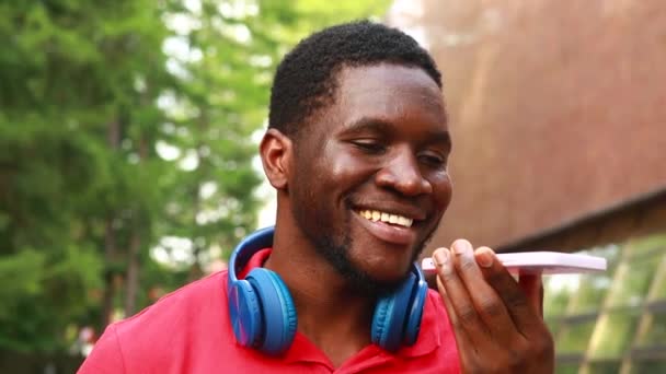 Junger Afroamerikanischer Mann Mit Kopfhörer Hals Mit Smartphone Sprachnachricht Sommerpark — Stockvideo