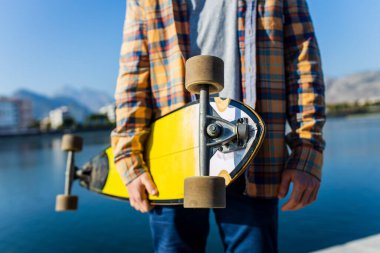 Güneşli yaz gününde, nehrin kenarında kaykay yaparken çekilmiş bir fotoğraf. .