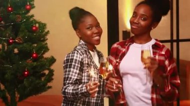 Pijamalı Afrikalı kadınlar evde kalıp kıvılcımlarla şampanya tokuşturuyorlar. .