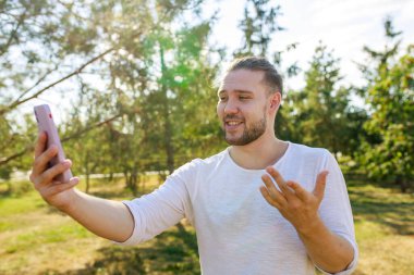 Beyaz ceketli mutlu adam yaz parkındaki arkadaşına ilginç bir hikaye anlatıyor..