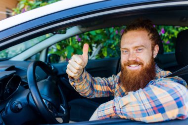 Uzun sakallı kızıl saçlı yakışıklı adam yaz tatilinde yeni arabasıyla geziye çıkıyor..