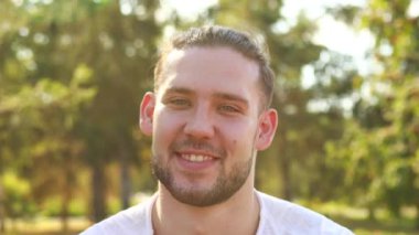 Genç adam dışarıdaki yaz parkına bakarken içten bir heyecan gösteriyor..