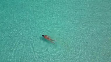 Genç bir kadın Maldivler 'in tropikal sularında şnorkelle yüzüyor..