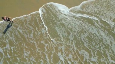 Genç ve sağlıklı bir kadın deniz sahilinde yoga ya da traks egzersizleri yapıyor..