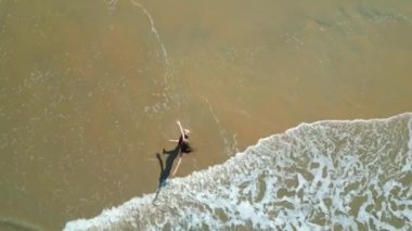 Genç ve sağlıklı bir kadın deniz sahilinde yoga ya da traks egzersizleri yapıyor..