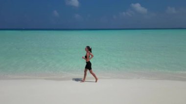 Sportif kadın ısınıyor. Maldivler sahilinde koşuyor. Sabah havası yukarıda..