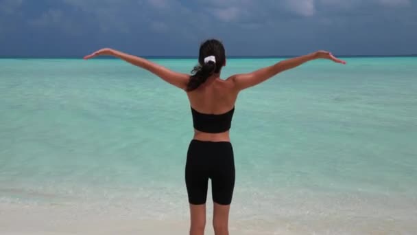 在马尔代夫海滩上做瑜伽练习以呼吸和镇静的妇女 — 图库视频影像