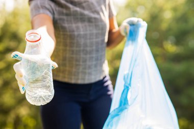 Afrika kökenli Amerikalı gönüllüler güneşli yaz parkında plastik çöp topluyorlar..