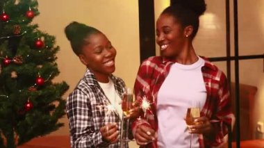 Pijamalı Afrikalı kadınlar evde kalıp kıvılcımlarla şampanya tokuşturuyorlar. .