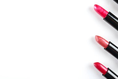 Arka arkaya üç farklı tonda, beyaz arkaplanda izole edilmiş ve metin için bir sürü kopya alanı olan üç parlak ruj. Güzellik ürününü kapat..