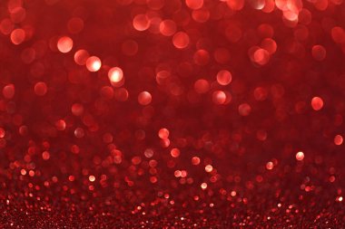 Bokeh efektli ve seçici odaklı kırmızı parıltılar. Parlak yakut ışıklarıyla şenlikli bir arka plan. Noel konsepti. Metin için alanı kopyala.