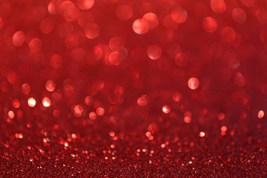 Bokeh efektli ve seçici odaklı kırmızı parıltılar. Parlak yakut ışıklarıyla şenlikli bir arka plan. Noel konsepti. Metin için alanı kopyala.