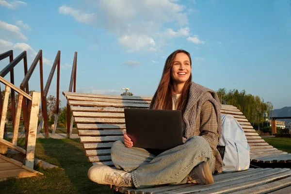 Νεαρή Χαμογελαστή Γυναίκα Κάθεται Φορητό Υπολογιστή Και Εργάζεται Στην Ξύλινη — Φωτογραφία Αρχείου