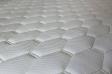 Hücre şekilli beyaz ortopedik yatak. Spinal hizalama ve basınç noktası rahatlaması için hipoalerjenik köpük matress. Kapat, metin ve arkaplan için boşluk kopyala.