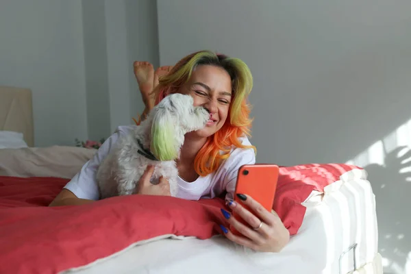 Çok Renkli Saçlı Genç Bir Kadın Yatak Odasında Köpeğiyle Selfie — Stok fotoğraf