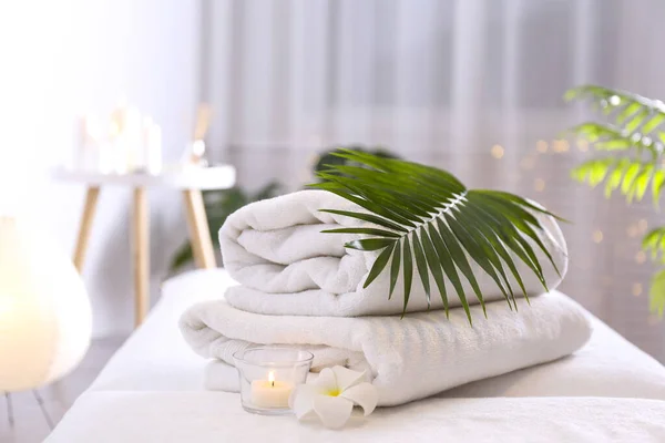 Een Massagetafel Ligt Een Stapel Zachte Handdoeken Samenstelling Met Symbolische — Stockfoto