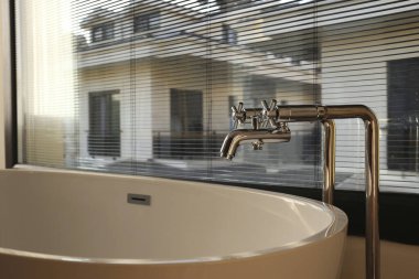 Doğal güneş ışığında ayakta duran bir küveti olan güzel bir banyo. Kapat, metin ve arkaplan için boşluk kopyala.