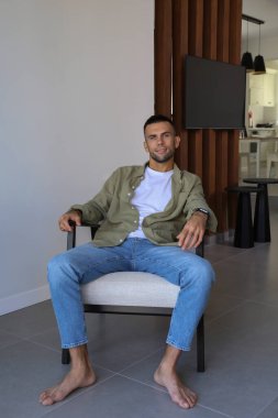 Düşünceli sakallı adam evde tek başına koltukta oturuyor. Kapat, kopyala alanı, iç arkaplan.