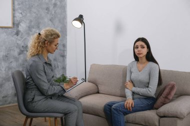 Terapi seansı konsepti. Genç bir kadın ofisinde yetişkin bir kadın psikiyatristten profesyonel yardım alıyor. Kapat, kopyala boşluk, arkaplan.