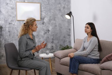 Terapi seansı konsepti. Genç bir kadın ofisinde yetişkin bir kadın psikiyatristten profesyonel yardım alıyor. Kapat, kopyala boşluk, arkaplan.