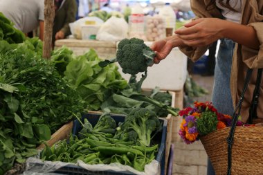 Çiftçi pazarından sebze, bitki ve sebze seçen tanınmamış genç bir kadın. Organik yerel ürün alışverişi. Kapat, kopyala boşluk, arkaplan.