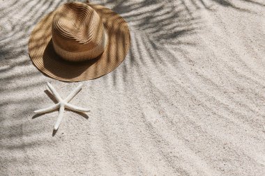 Yaz titreşimleri. Kumlu bir plajda geniş bir hasır şapka ve güneş gözlüğü. Metin için alanı kopyala.