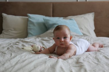 Yatakta 4 aylık şirin bir bebek. Boşluğu kopyala, arkaplan.