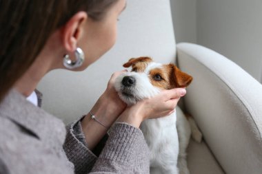 Evde köpeğiyle oynayan genç bir kadın. Boşluğu kopyala, arkaplan.