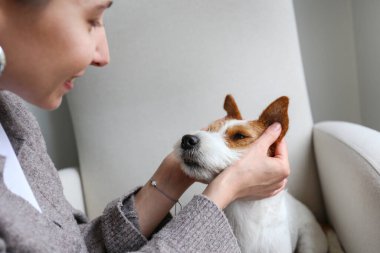 Evde köpeğiyle oynayan genç bir kadın. Boşluğu kopyala, arkaplan.