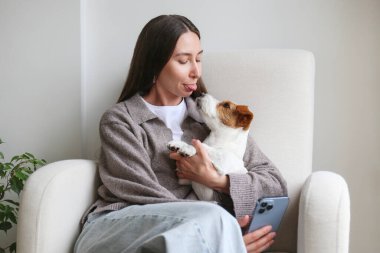 Genç bir kadın köpeğiyle selfie çekiyor. Boşluğu kopyala, arkaplan.
