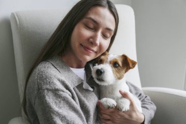 Genç bir kadın köpeğine sarılıyor. Boşluğu kopyala, arkaplan.