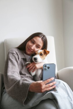 Genç bir kadın köpeğiyle selfie çekiyor. Boşluğu kopyala, arkaplan.